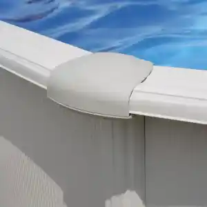 Close-up of a white curved post cap on a pool fence with blue water beyond.