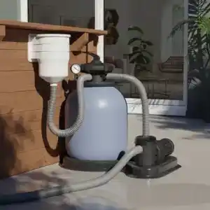 Above-ground pool filter pump with hoses connected on a patio near a sliding door and wooden planter.