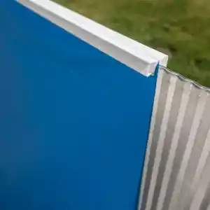 Close-up of a blue panel framed by a white edge, with a corrugated metal sheet at the side.
