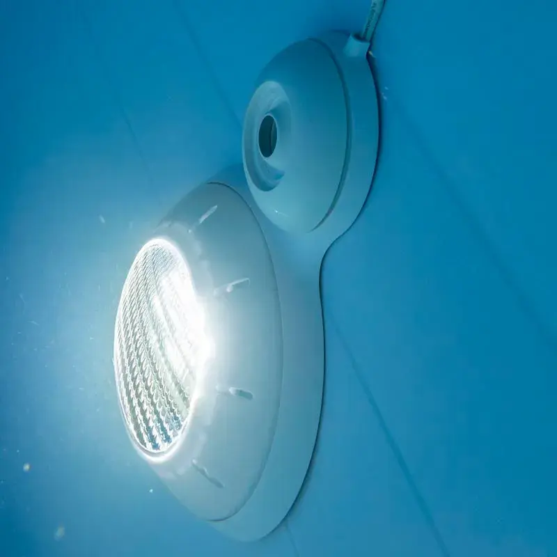 plpb14-2 | PisciManía Round pool light mounted on a blue wall, emitting a bright white LED glow